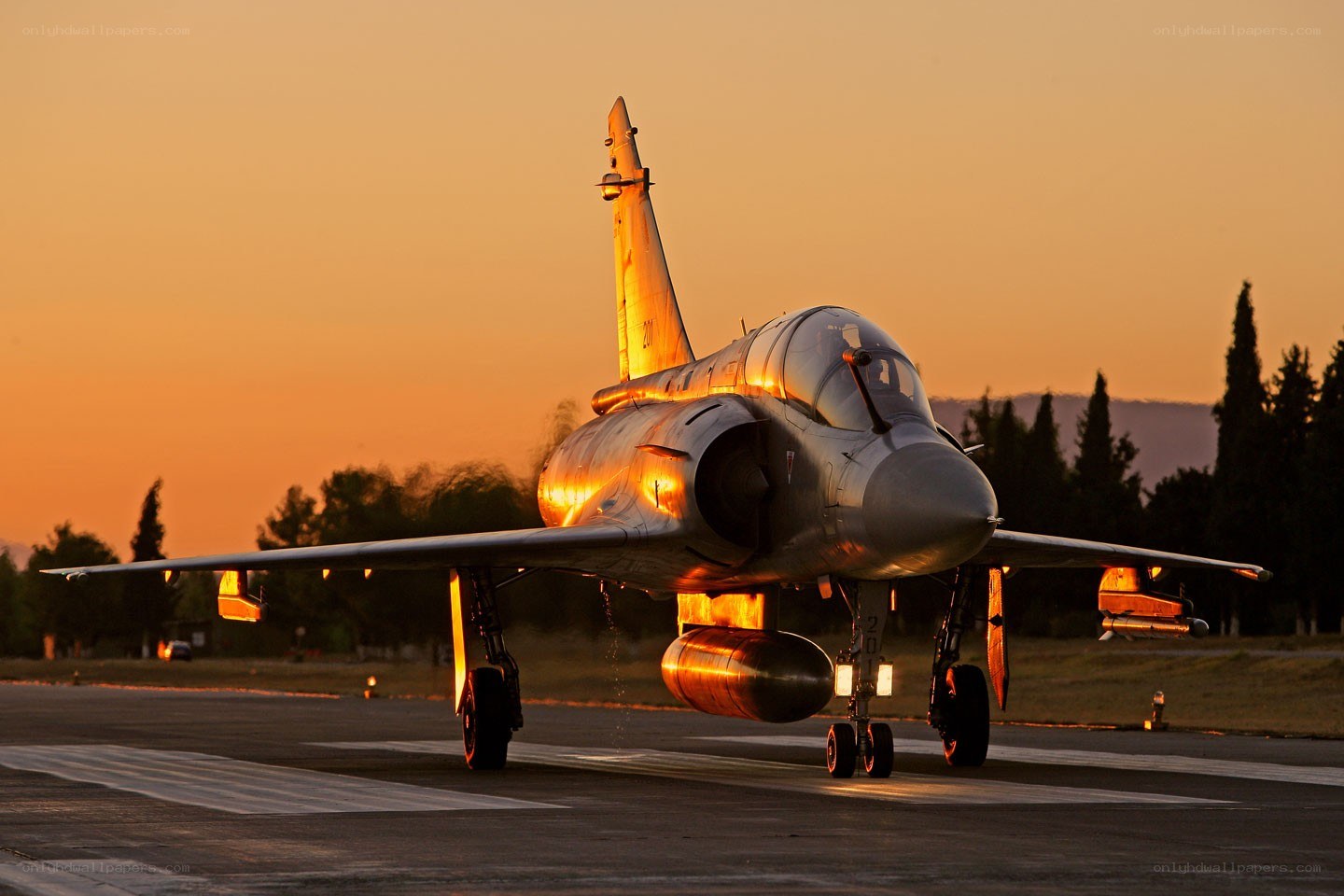 Jet fighter on runway at sunset
