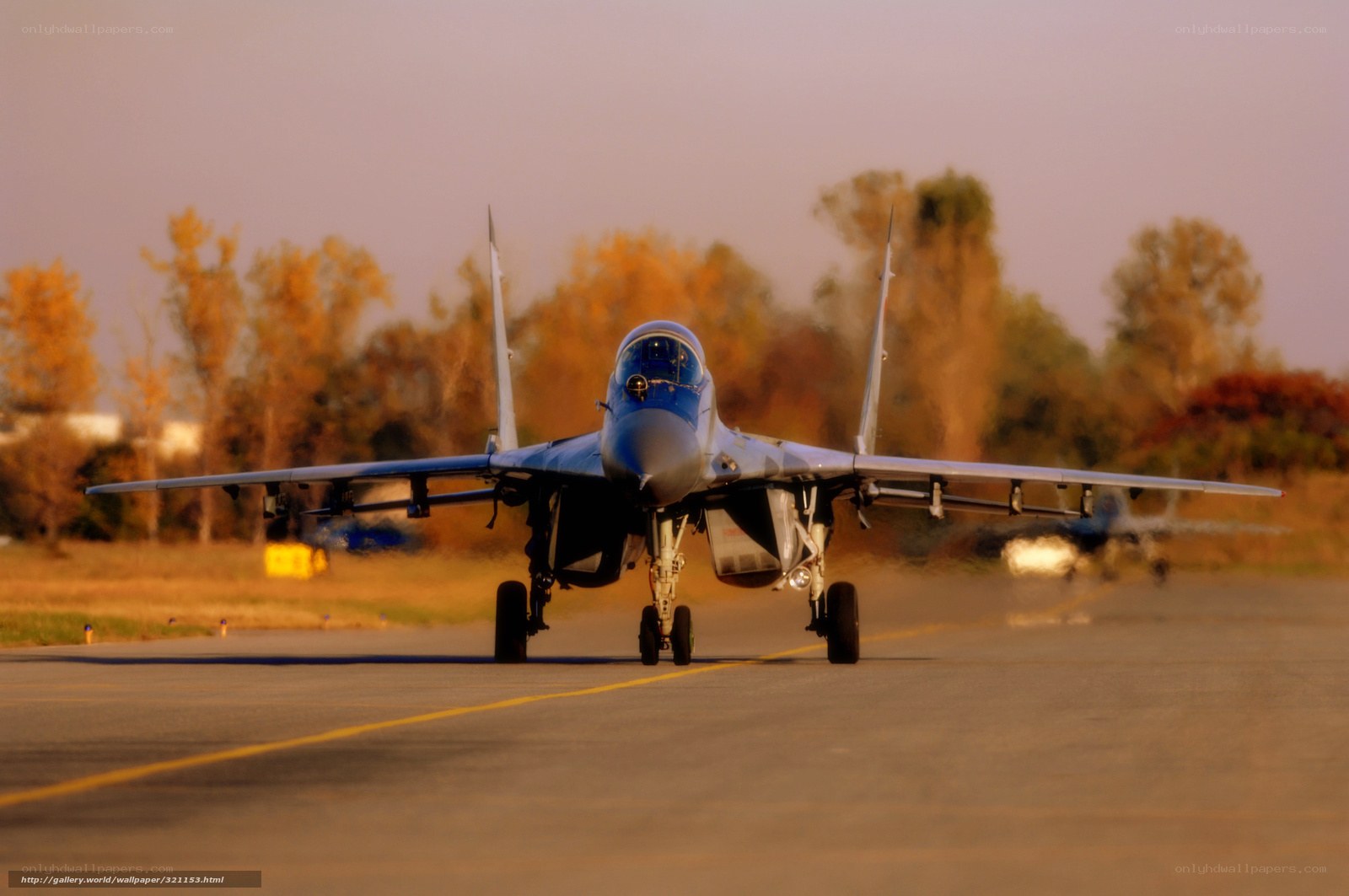 Jet fighter on runway at sunset