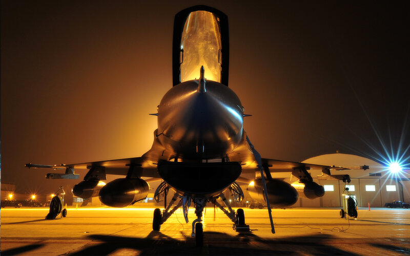 Jet fighter on tarmac at night