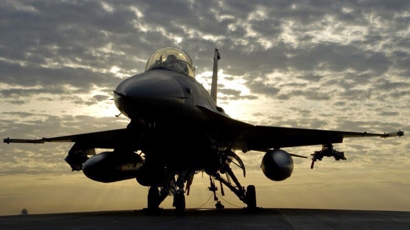 Jet fighter on tarmac at sunset
