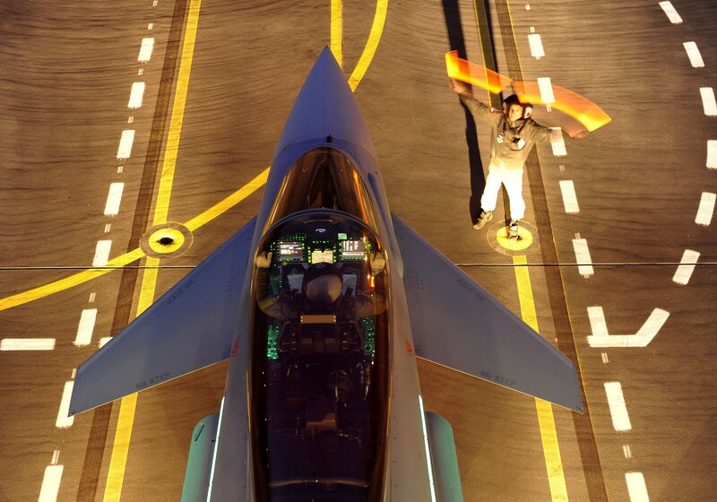 Jet fighter on tarmac with ground crew