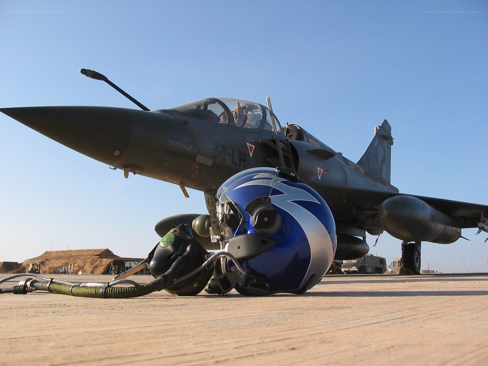 Jet fighter on tarmac with helmets