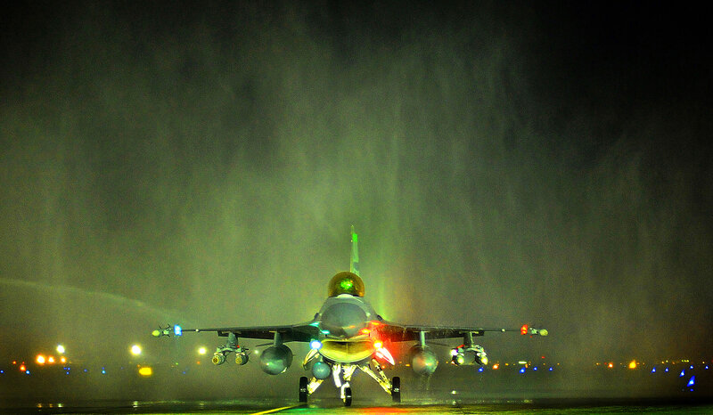 Jet fighter on wet runway at night