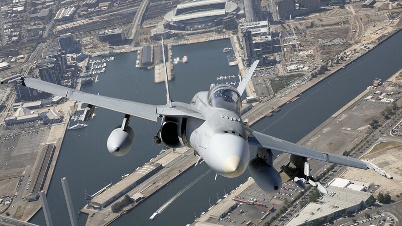 Jet fighter over city harbor