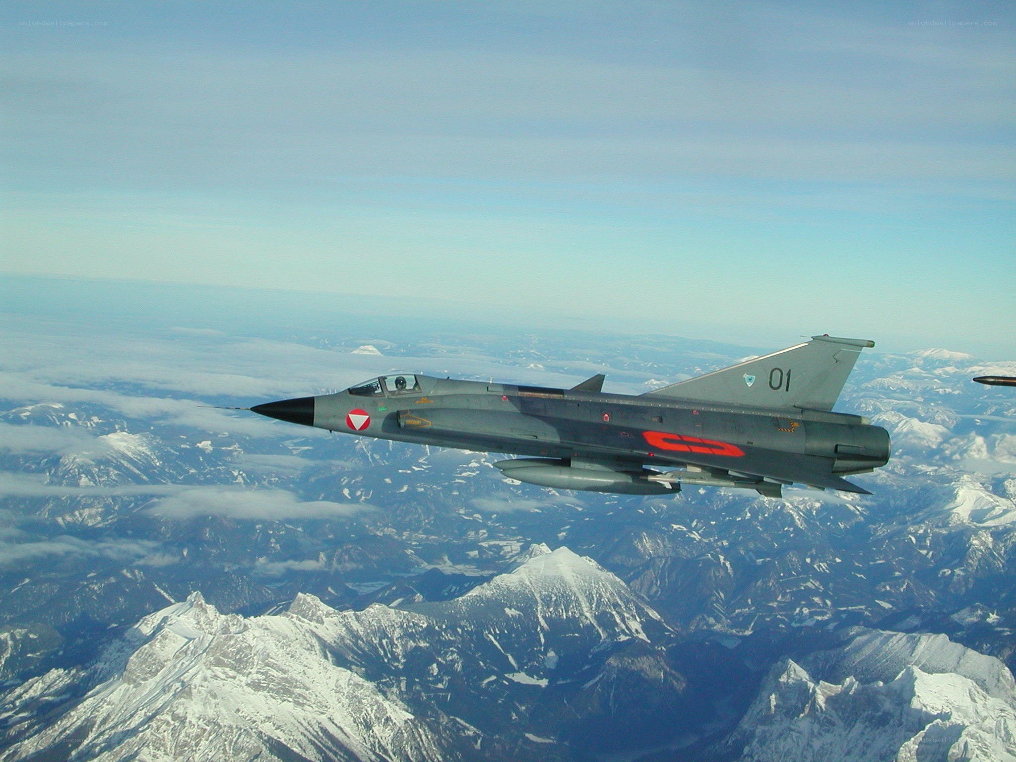 Jet fighter over snowy mountains