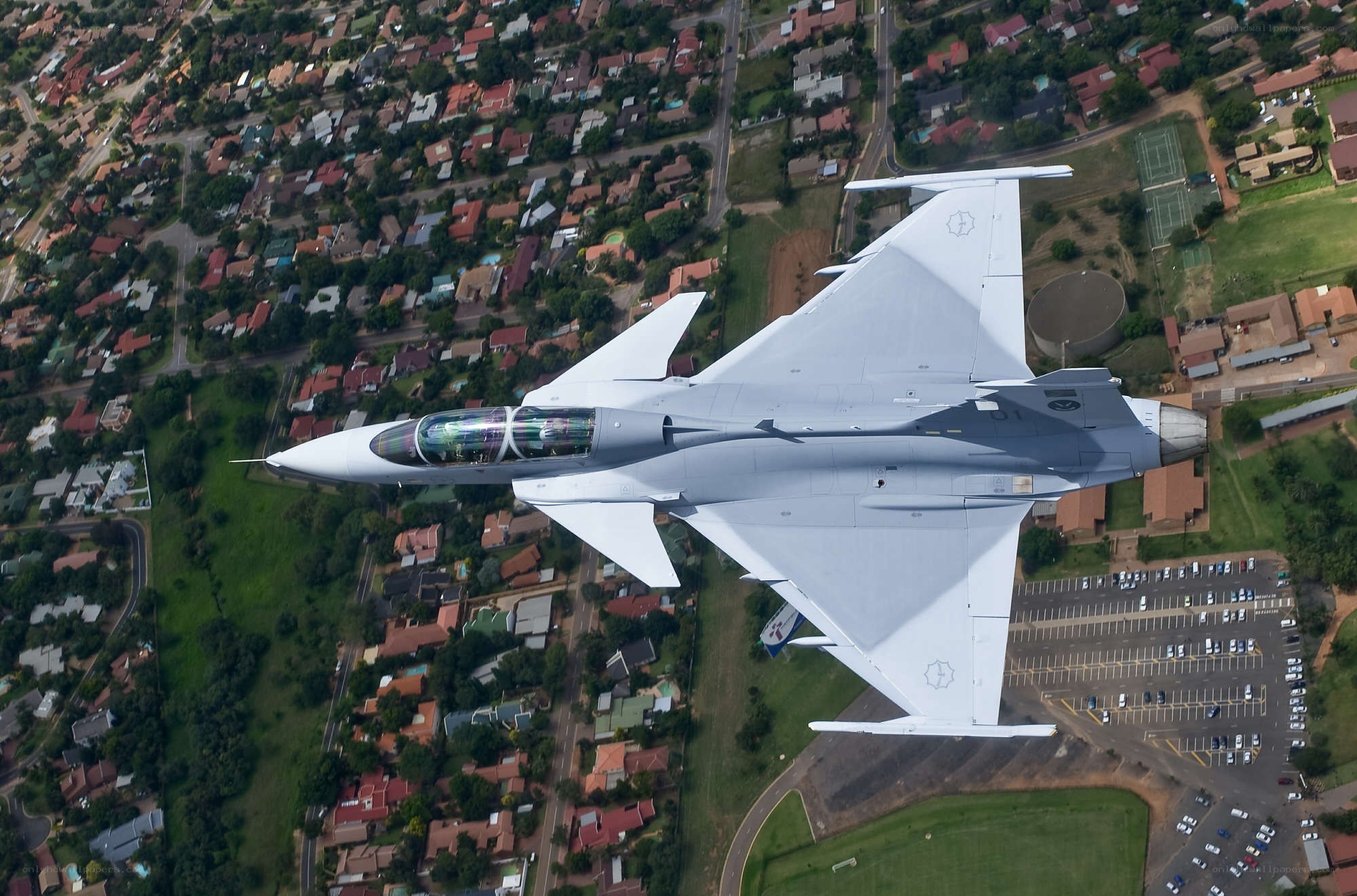 Jet fighter over suburban area
