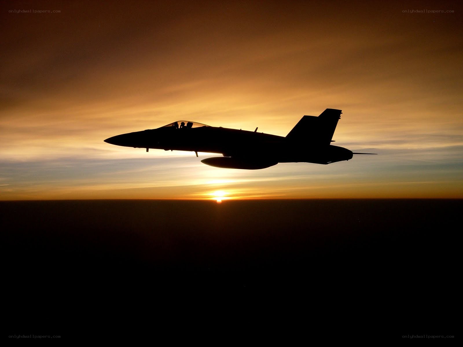 Jet fighter silhouette at sunset