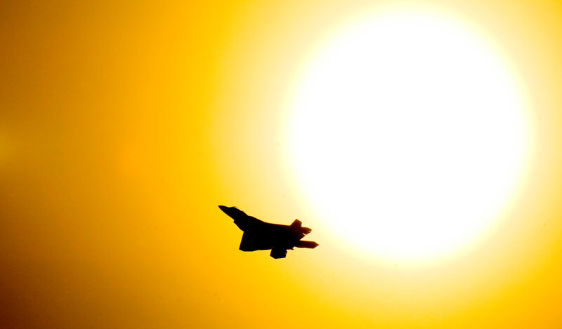 Jet fighter silhouette at sunset