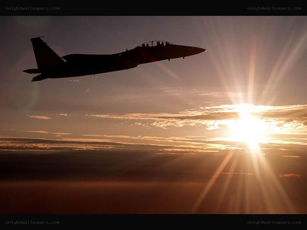 Jet fighter silhouette at sunset