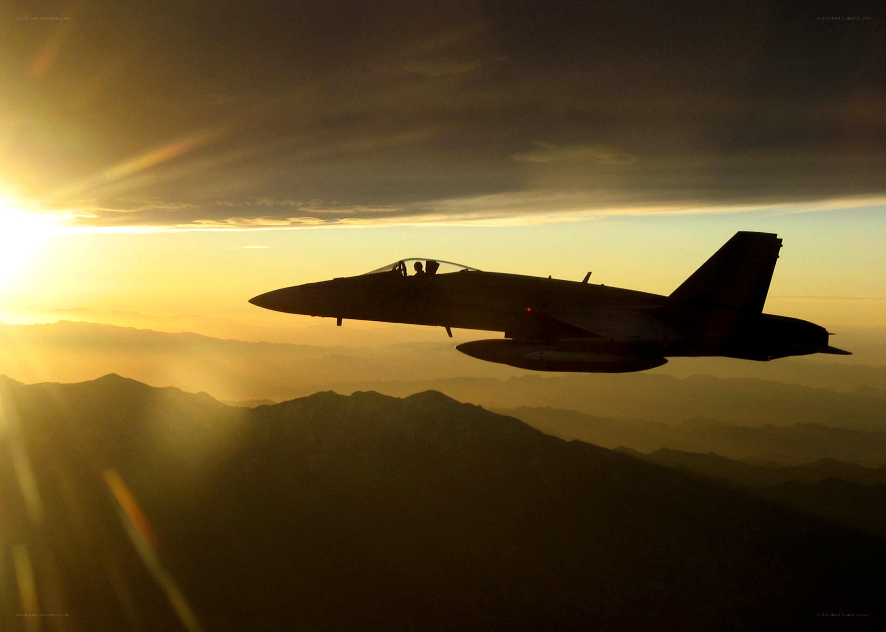 Jet fighter silhouetted at sunset