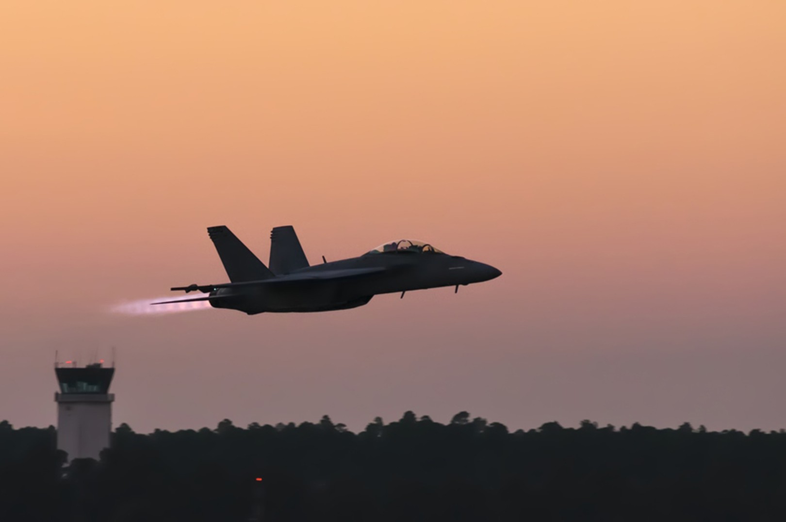 jet fighter taking off at dusk