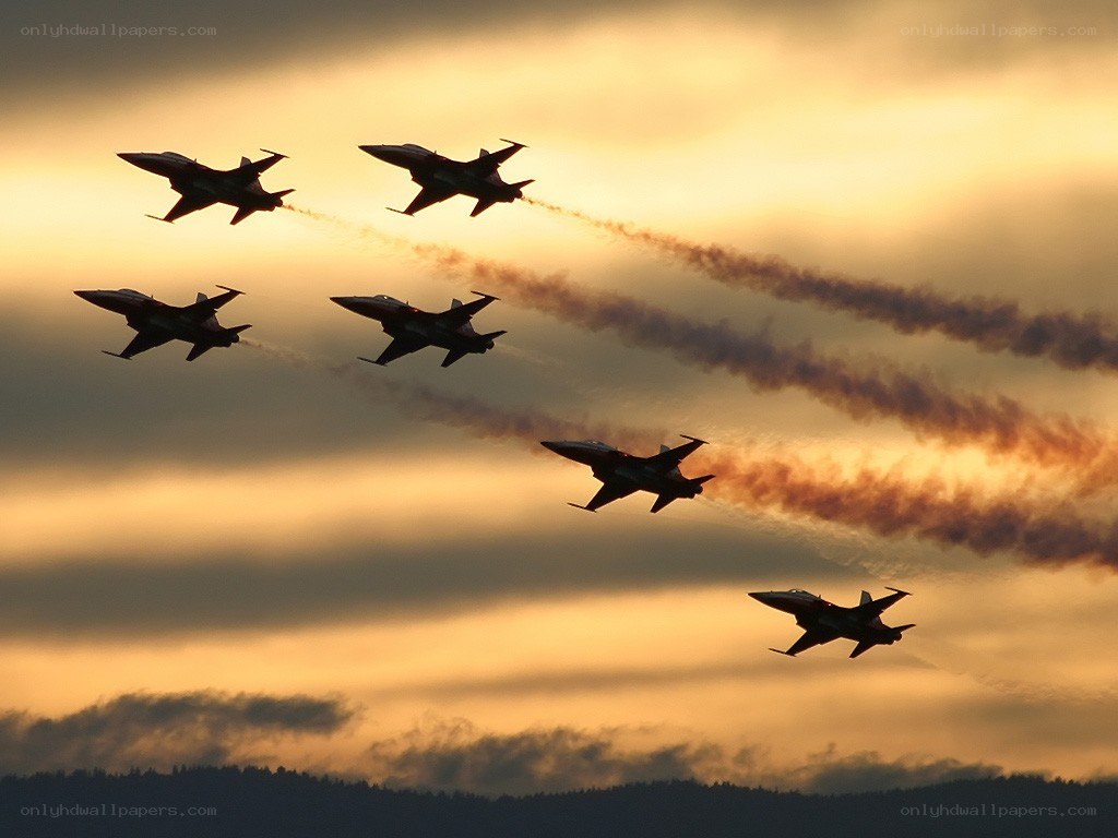 Jet fighters in formation at sunset