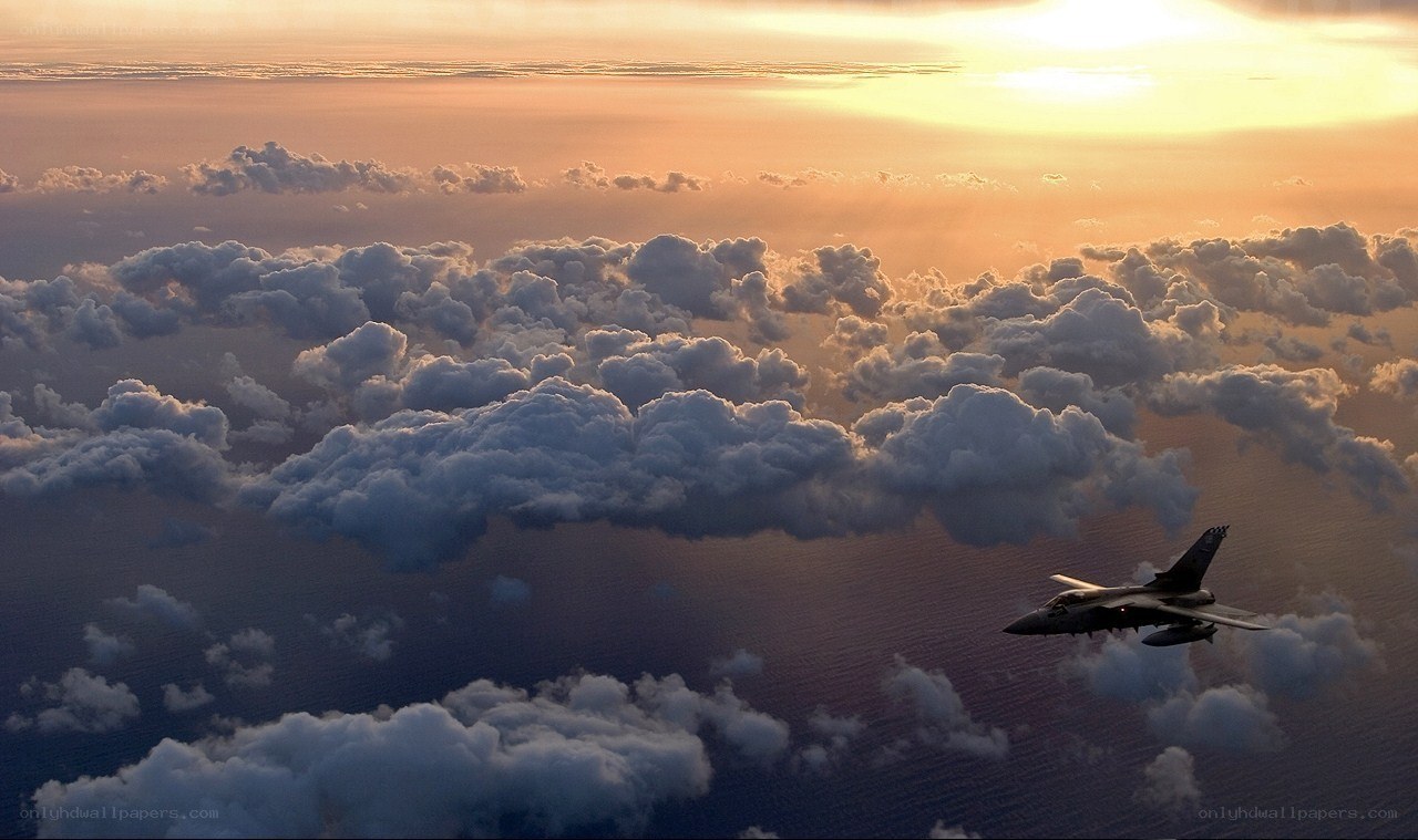 Jet flying above clouds at sunset