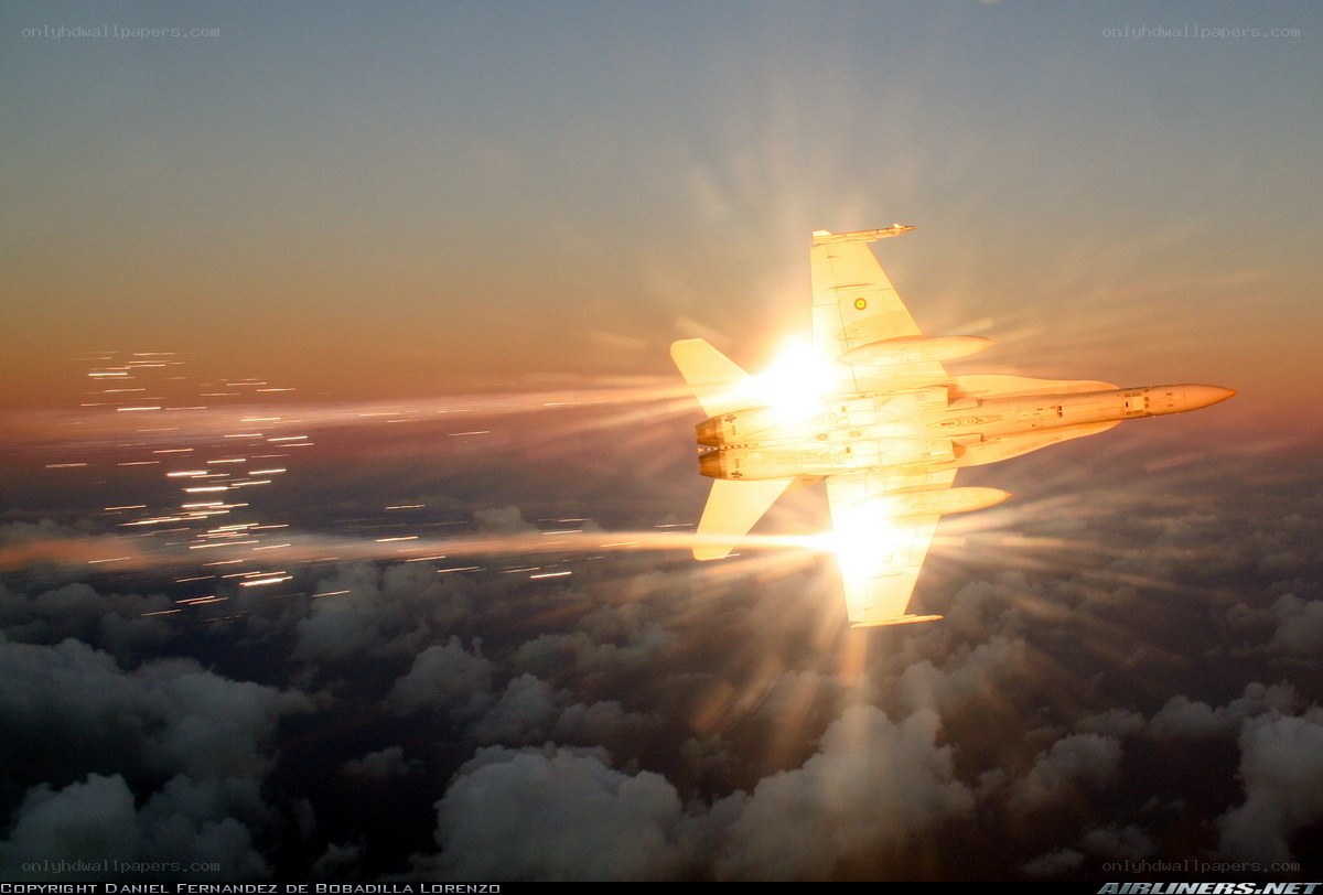 Jet flying over clouds at sunset