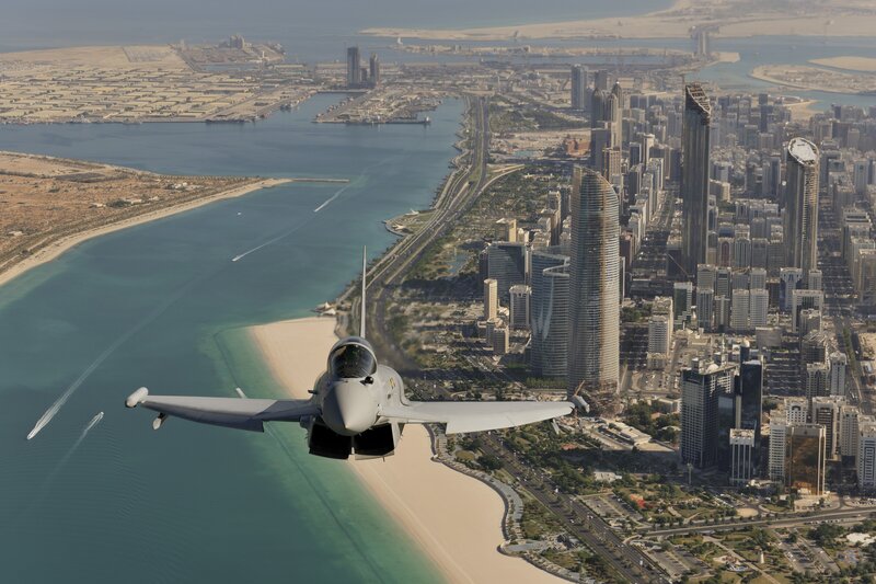 Jet flying over coastal city