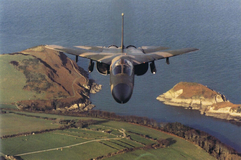 Jet flying over coastal landscape