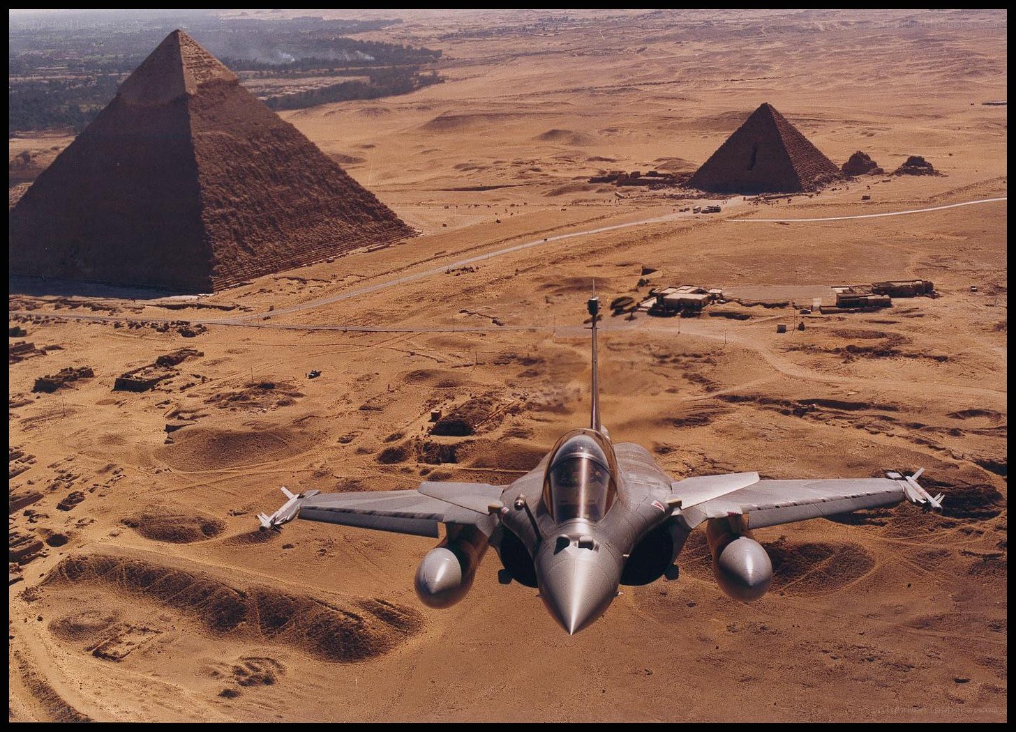 Jet flying over pyramids