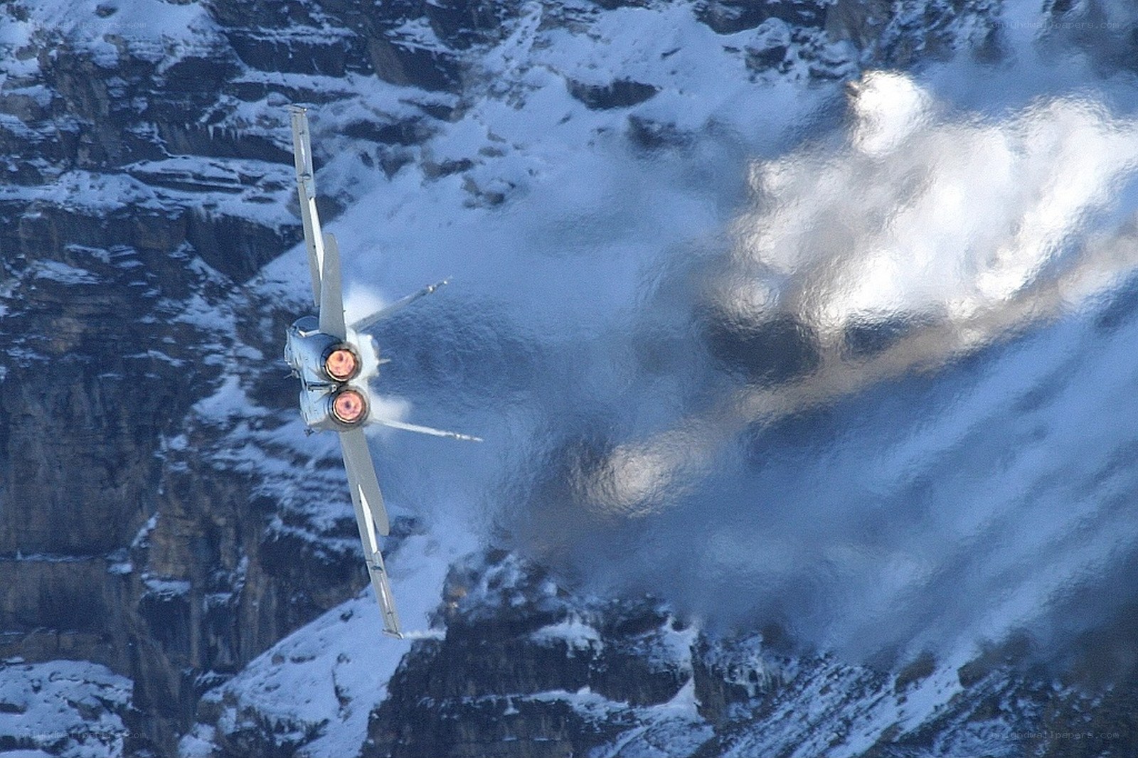 Jet flying over snowy mountains