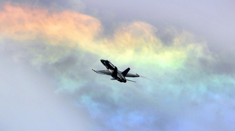 Jet flying through colorful clouds