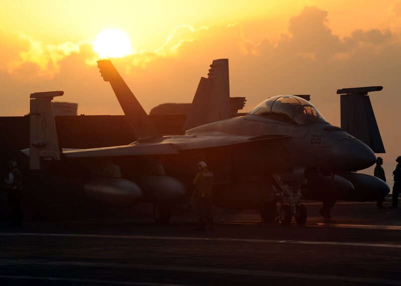 Jet on aircraft carrier at sunset