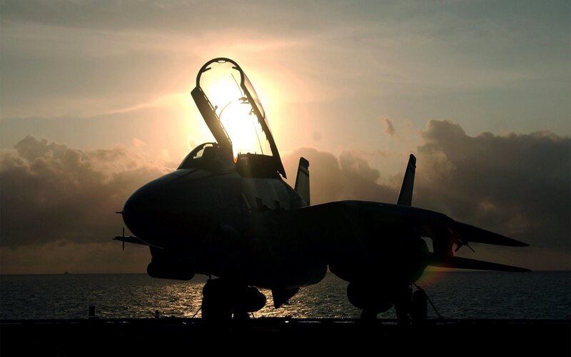 Jet on aircraft carrier at sunset