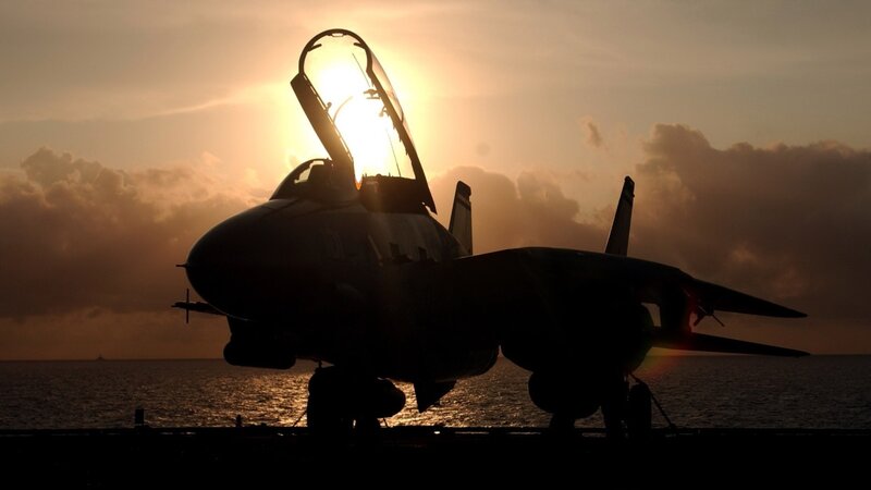 Jet on aircraft carrier at sunset