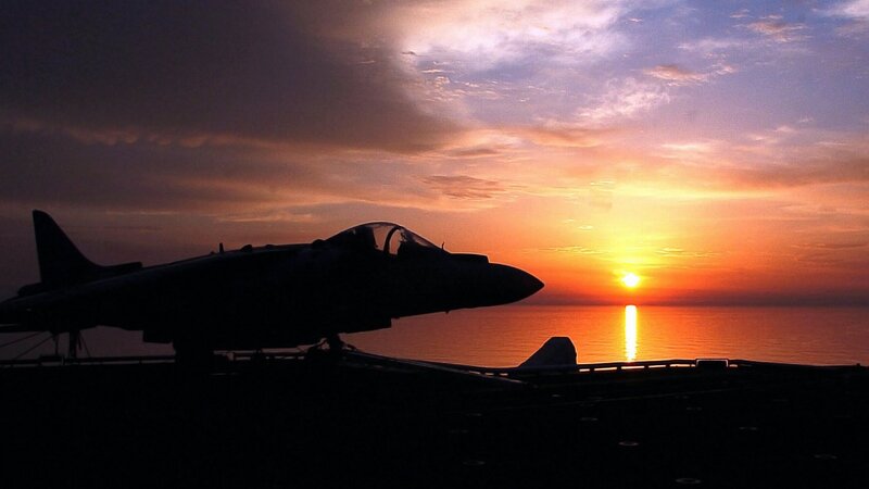 Jet on aircraft carrier at sunset