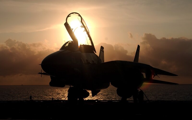 Jet on aircraft carrier at sunset