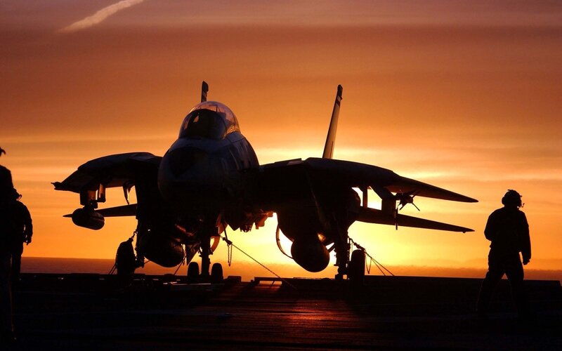 Jet on aircraft carrier at sunset