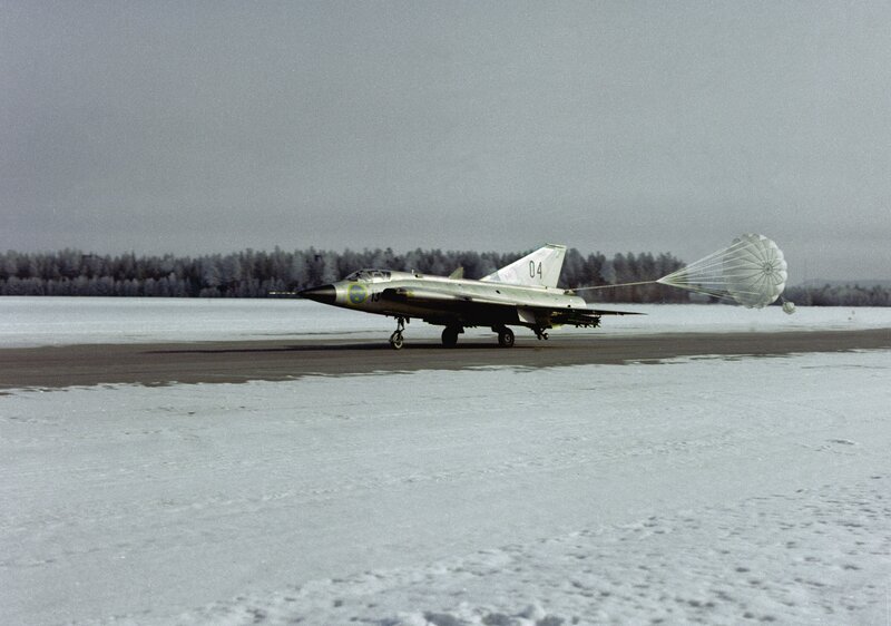 Jet on snowy runway with parachute