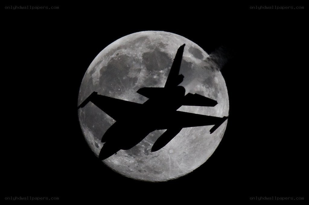 Jet silhouetted against the moon