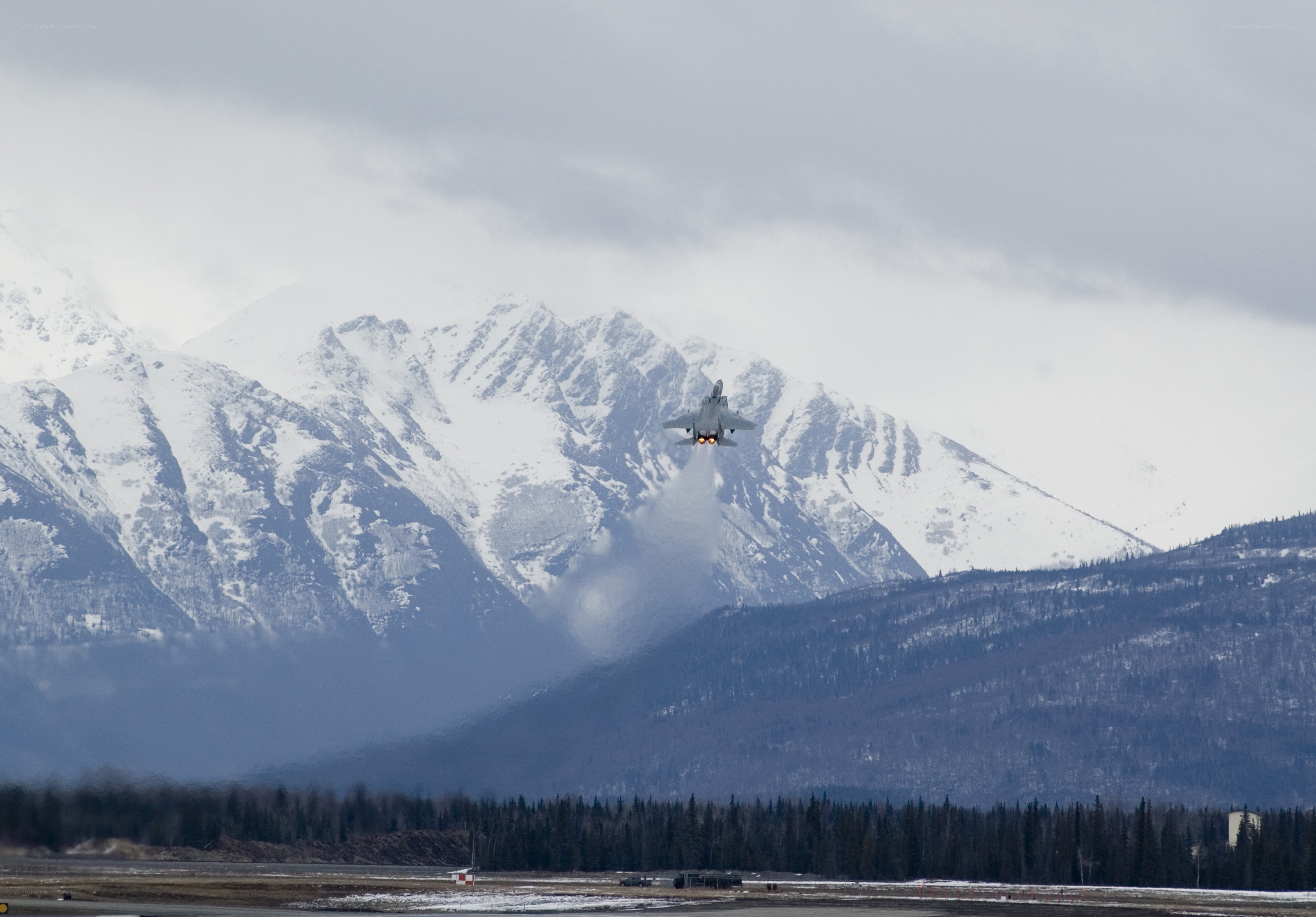 Jet taking off over snowy mountains