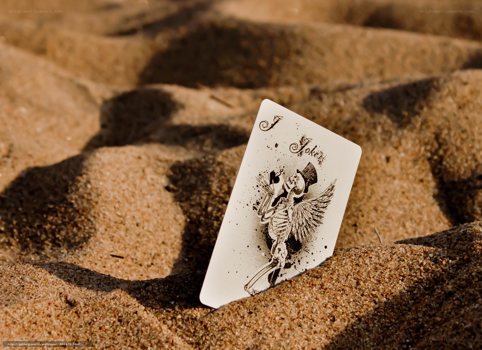 Joker card in the sand
