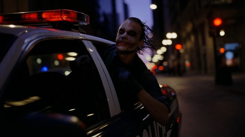 Joker in police car at night