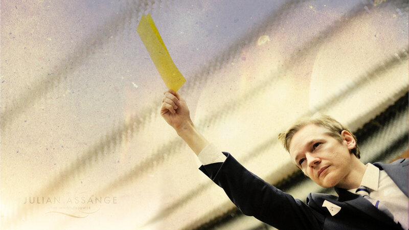 Julian Assange holding yellow paper