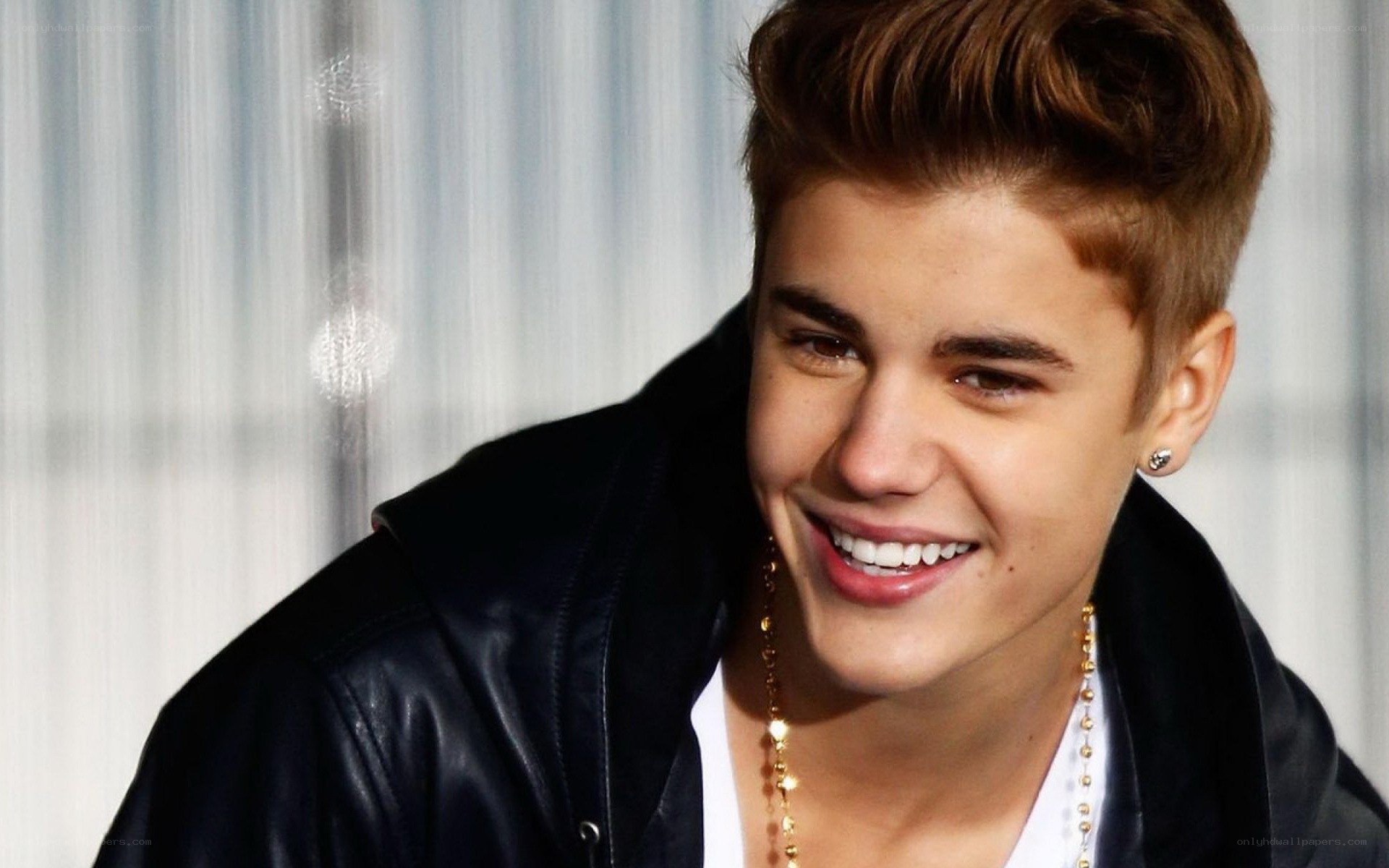 Justin Bieber smiling in leather jacket