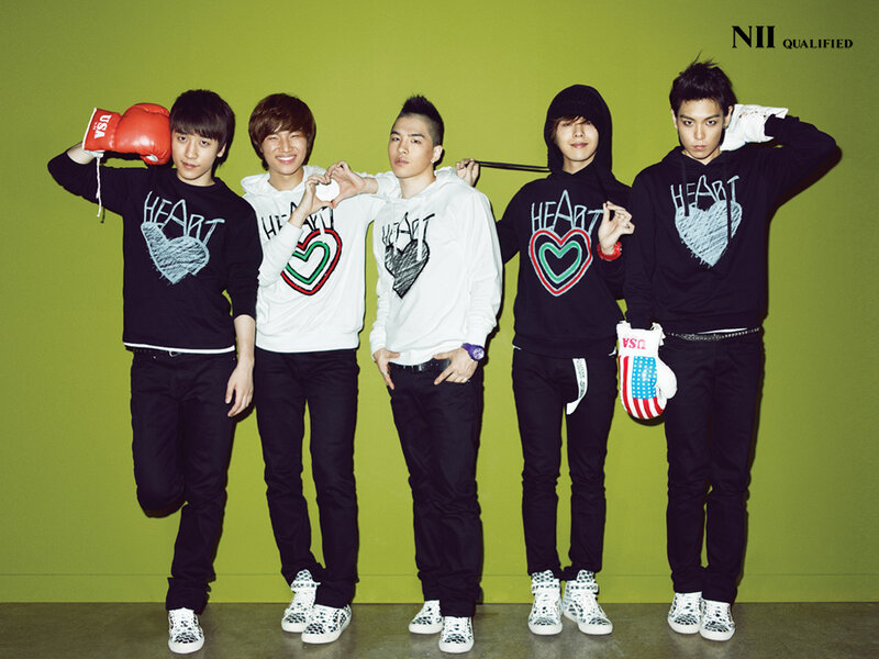 K-pop group in heart-themed sweaters