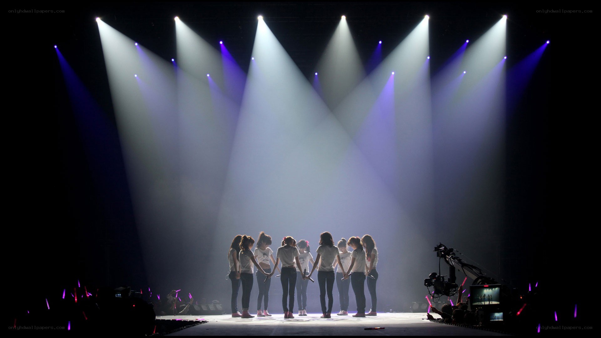 K-pop group on stage under spotlights