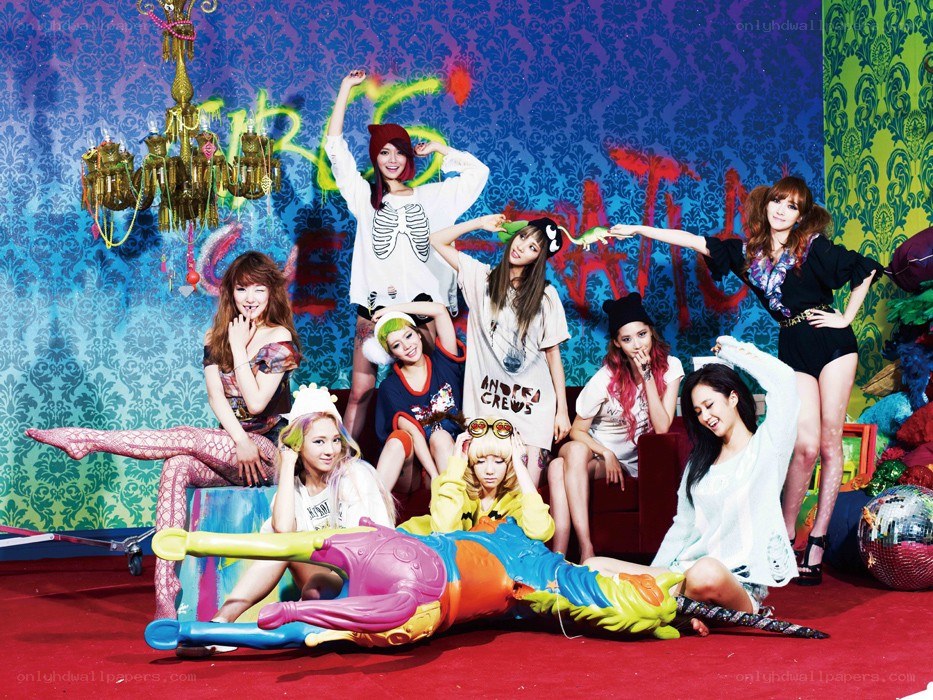 K-pop group posing in colorful room