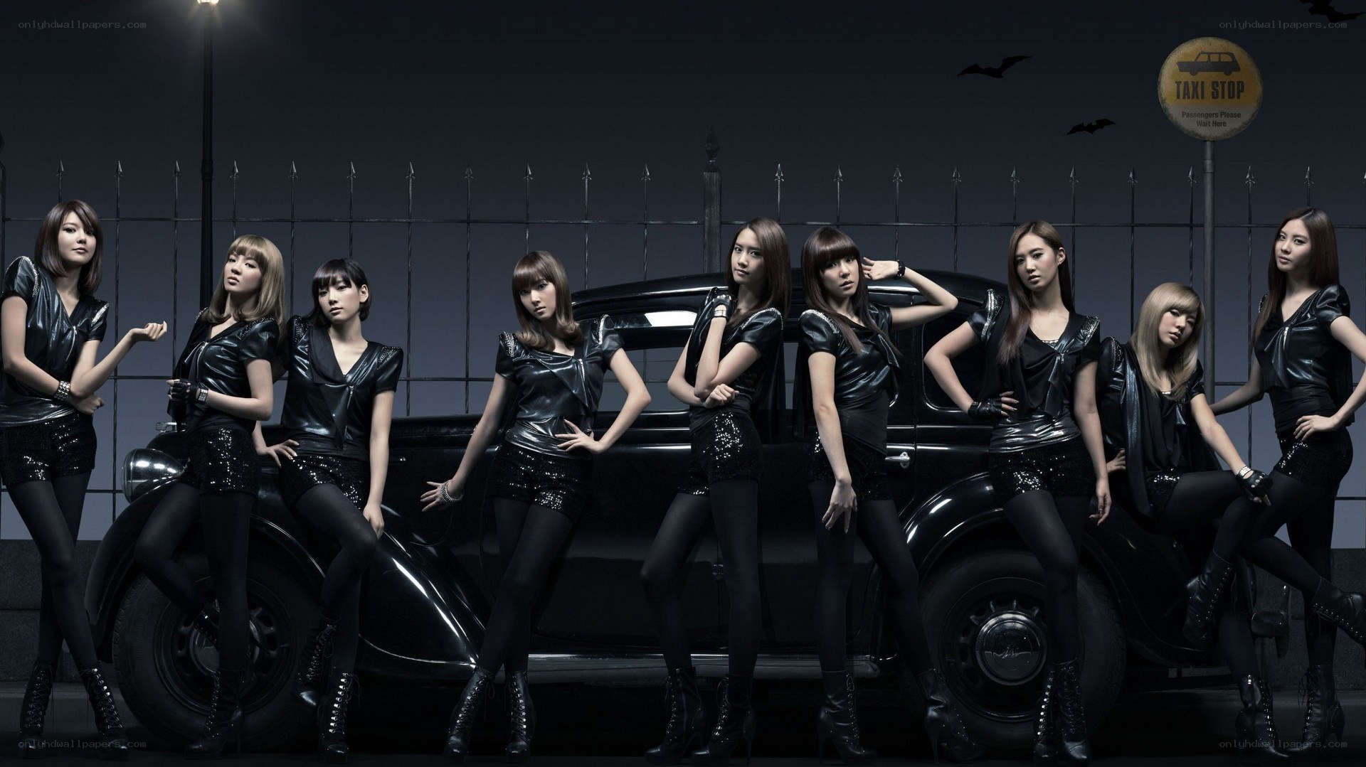 K-pop group posing with vintage car