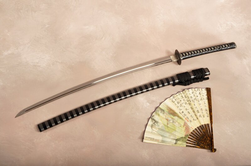 Katana and fan on textured surface