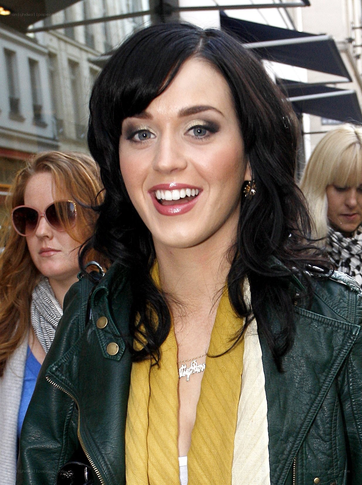 Katy Perry smiling in a leather jacket