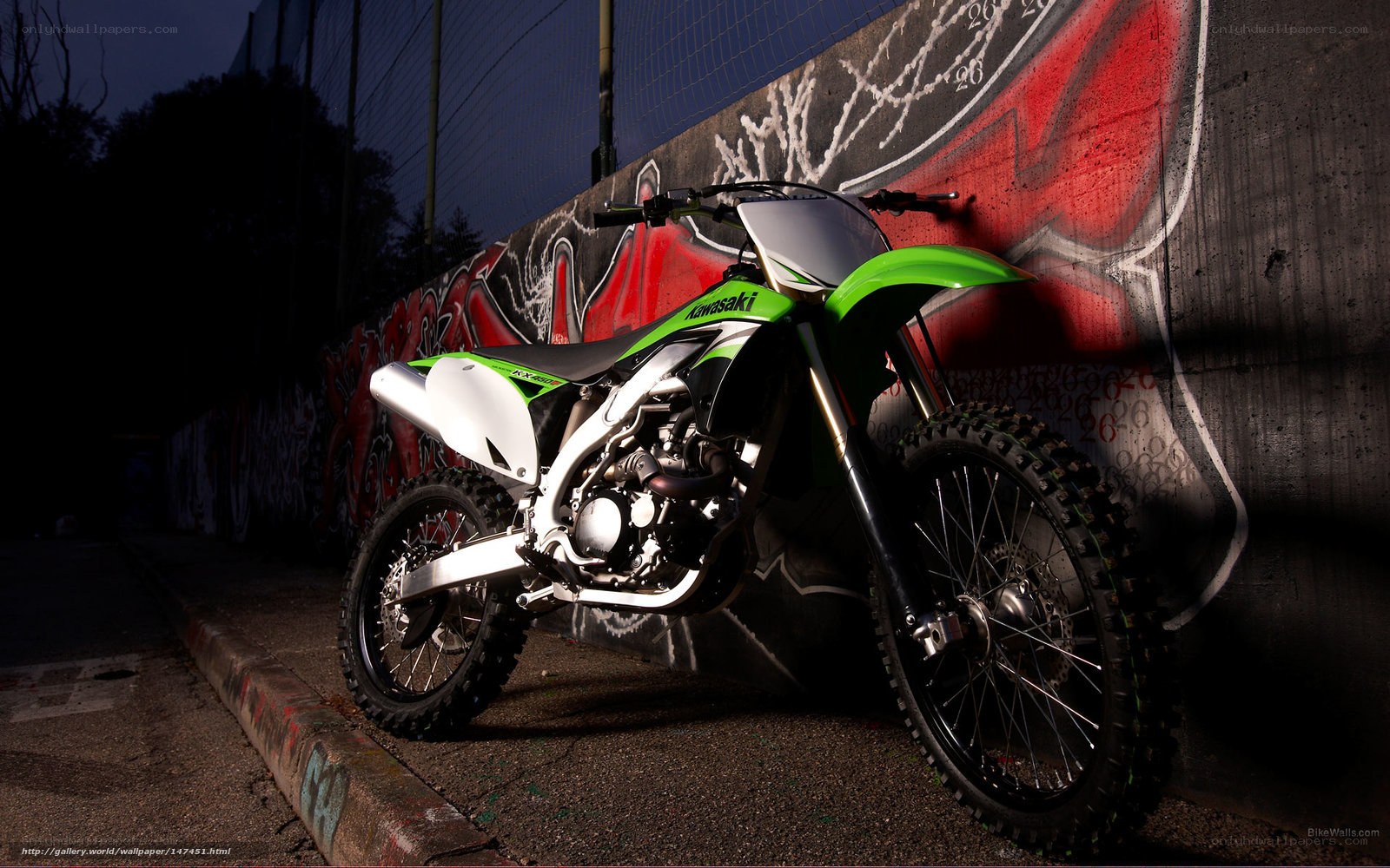 Kawasaki dirt bike against graffiti wall