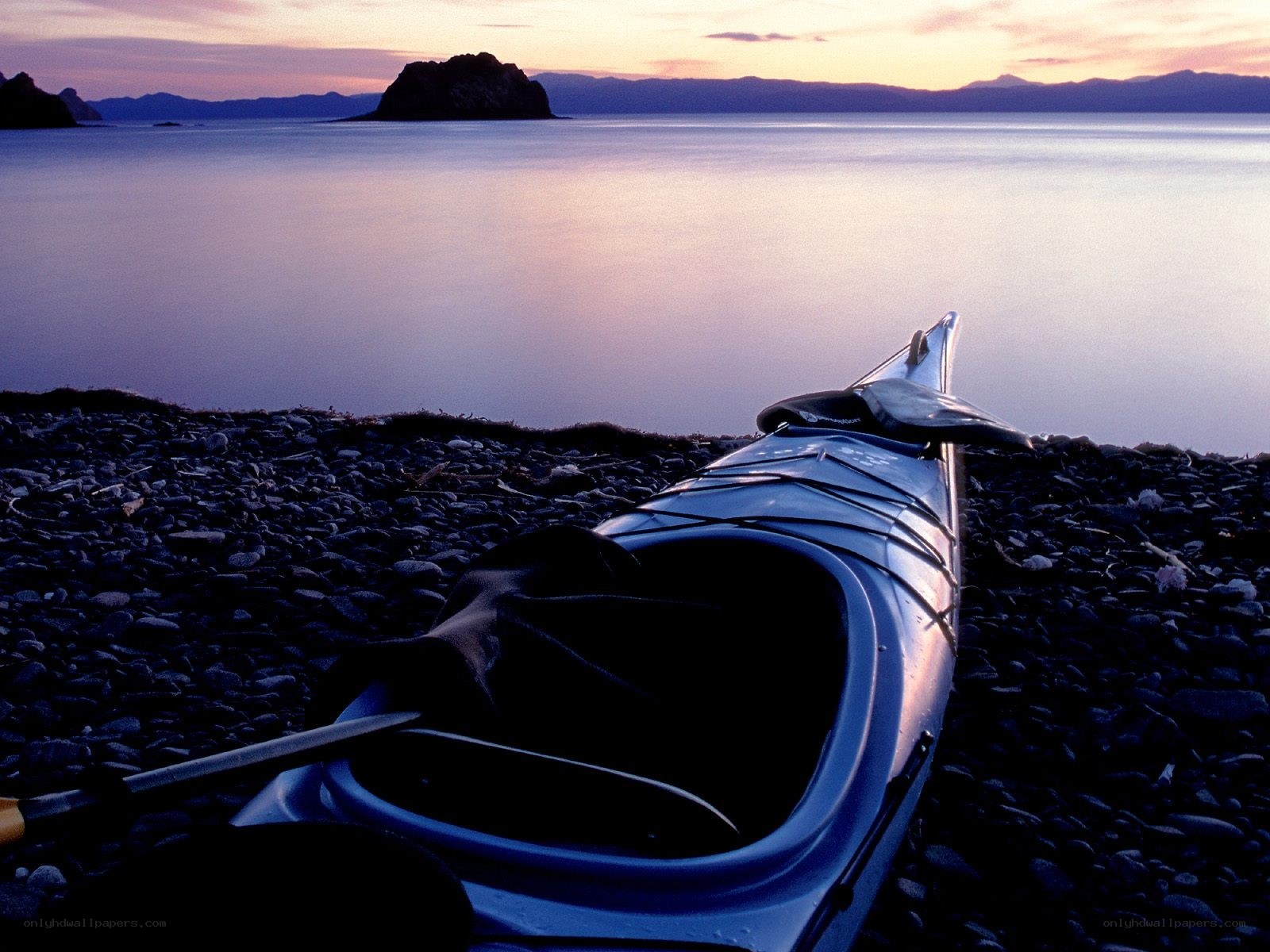 kayak on a pebble beach at sunset