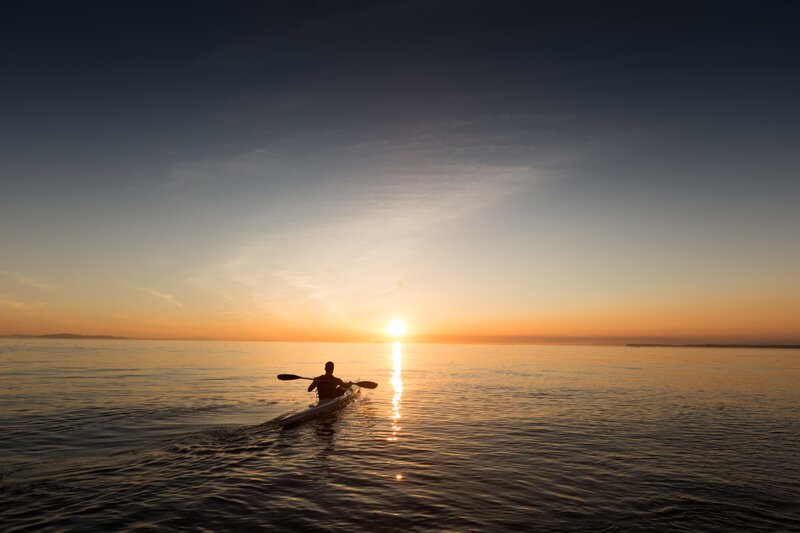 kayaker at sunset on calm water