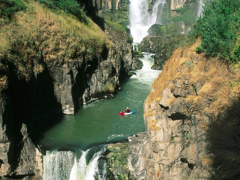 Kayaker in a canyon with waterfalls
