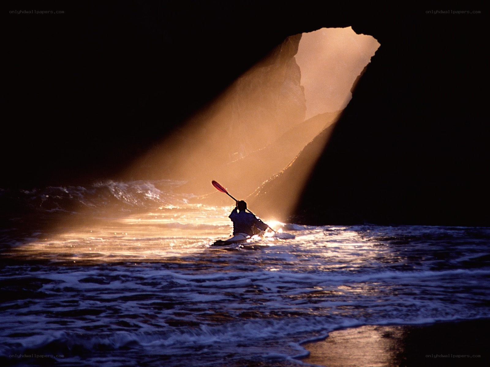 kayaker in a cave at sunset