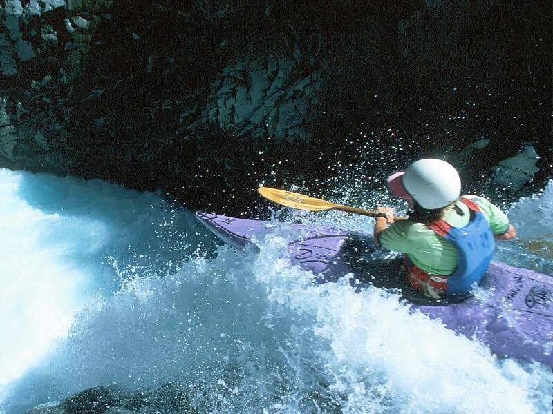 kayaker navigating whitewater rapids