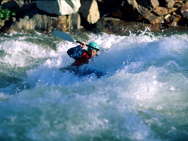 kayaker navigating whitewater rapids
