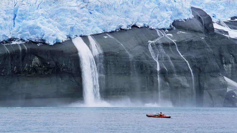 kayaker near glacier waterfall